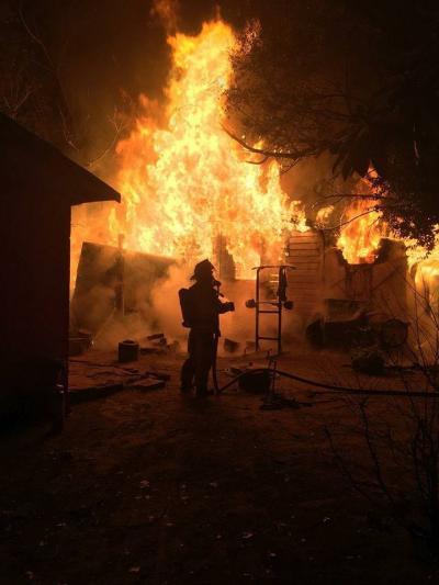 Firefighter in front of burning home